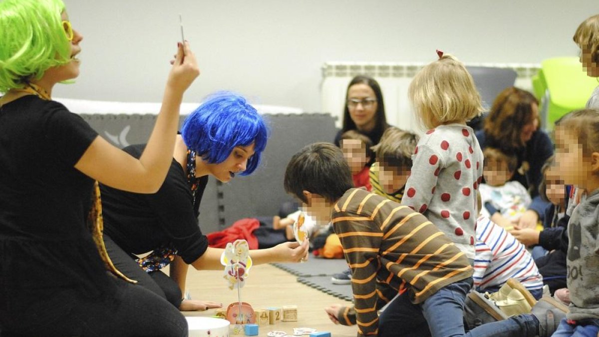 Dos de las educadoras con los niños que asistieron al taller del pasado martes.-EL PUENTE