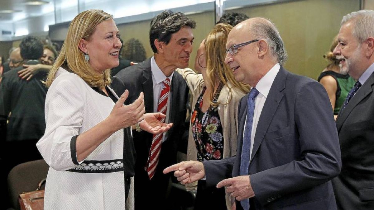 La consejera de Hacienda, Pilar del Olmo, bromea con el ministro Cristóbal Montoro antes de comenzar la reunión en Madrid.-Ical