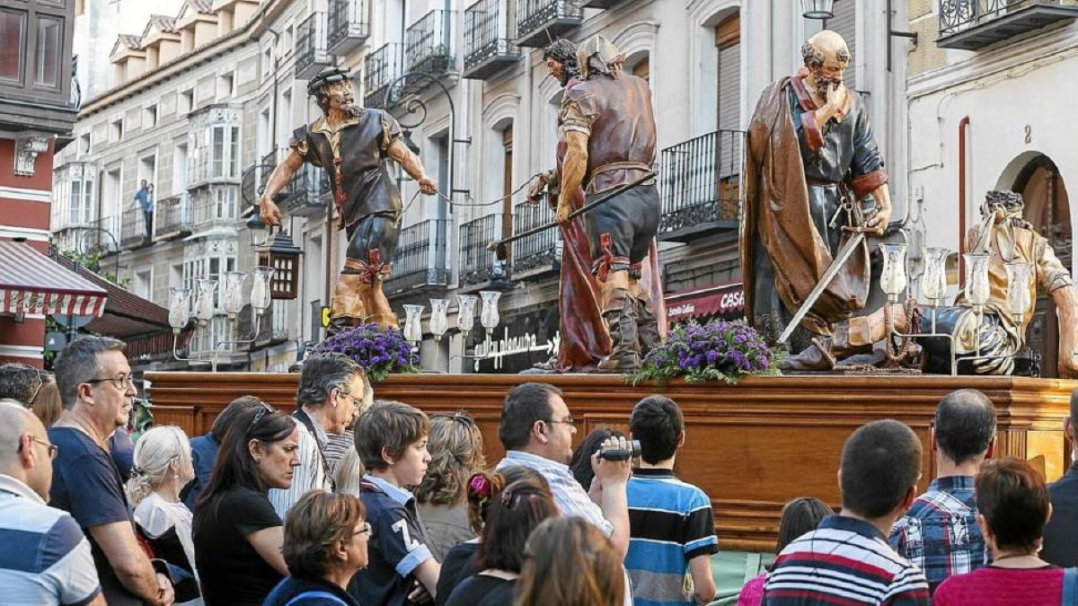 Algunos fieles observan el paso de una de las tallas durante la procesión de Jueves Santo del pasado año-Pablo Requejo