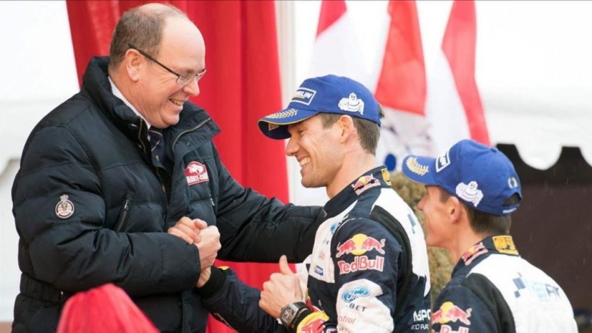 Sébastien Ogier estrecha la mano del príncipe Alberto de Mónaco junto a su copiloto, Julien Ingrassia, este domingo en Mónaco.-AFP / YANN COATSALIOU
