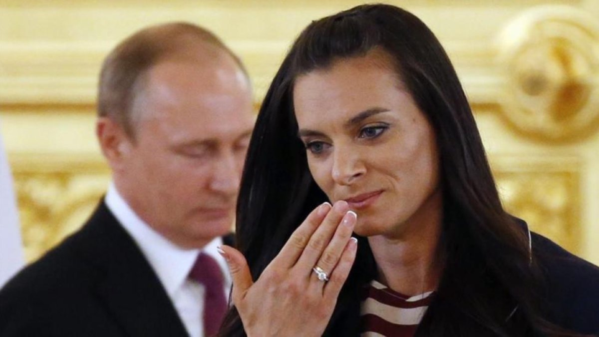 Isinbayeva, delante de Putin, en el acto de despedida del equipo olímpico.-EFE / YURY KOCHETKOV