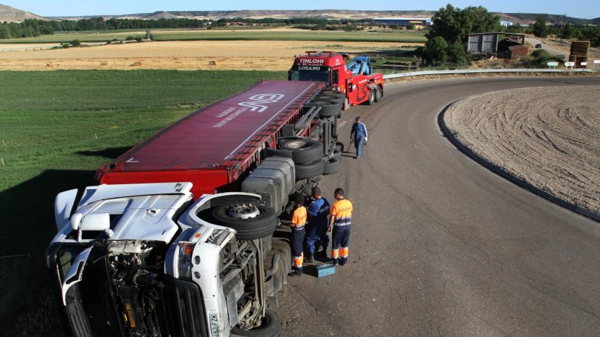 Un trailer vuelca en una rotonda de acceso a la fábrica de papel Europac, en Dueñas (Palencia), el conductor herido ha tenido que ser rescatado por bomberos de Palencia y trasladado en ambulancia a centro hospitalario de la capital.-ICAL