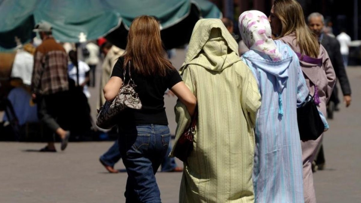 Mujeres vestidas al uso occidental junto a otras con vestimentas tradicionales, en la plaza Jemaa El Fna, en Marraquech, en una imagen de archivo.-XAVIER JUBIERRE