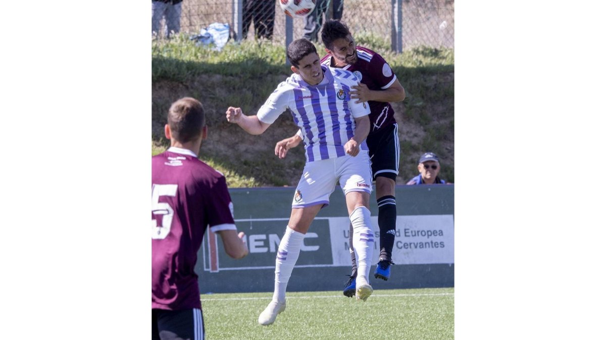Miguel intenta cabecear el balón ante un rival.-MIGUEL ÁNGEL SANTOS