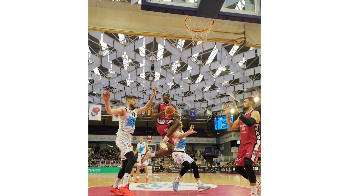 Frank Bartley penetra ante el ‘gigante’ Rozitios, en una imagen del partido de Luiga jugado el pasado día 5 de enero en Pisuerga. M. A. SANTOS