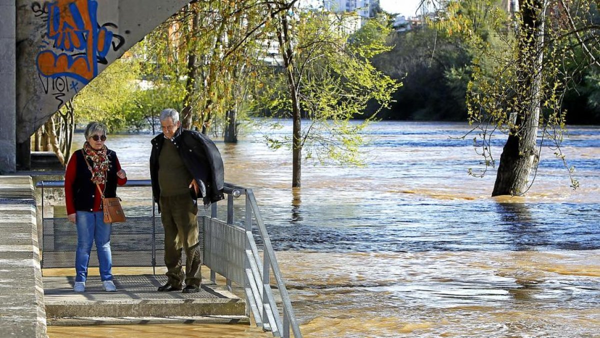 Una pareja observa la crecida del Caudal del Pisuerga en Valladolid.-J. M. LOSTAU