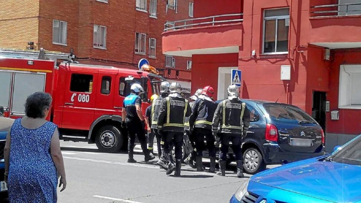 Un policia y varios bomberos junto al turismo volvado en el cruce de las calles Málaga y Huelva, en Delicias.-Ical