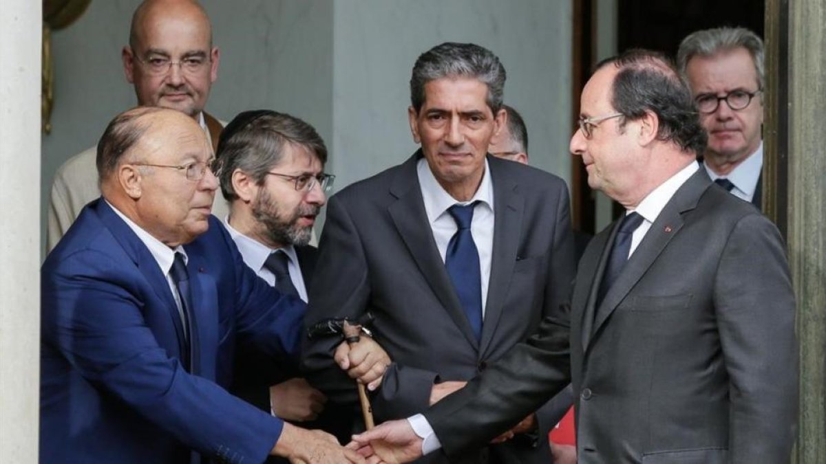Hollande estrecha la mano del rector de la Gran Mezquita de París, Dalil Boubakeur (izquierda), tras el encuentro en el Elíseo.-AP / THOMAS PADILLA