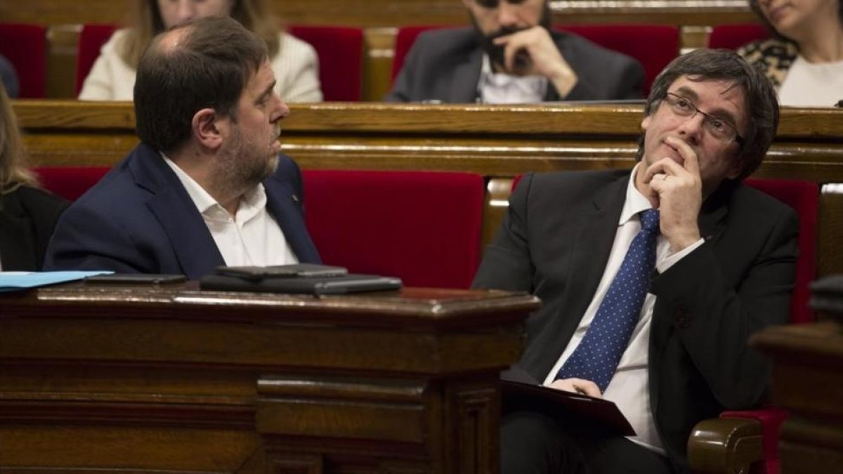 El 'president' Carles Puigdemont y el vicepresidente Oriol Junqueras, en el hemiciclo del Parlament.-ALBERT BERTRAN
