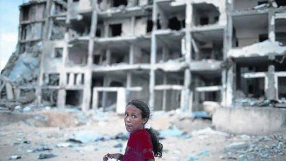 Una niña palestina junto un bloque de casas destruido en el norte de la franja de Gaza.-Foto: REUTERS / SUHAIB SALEM