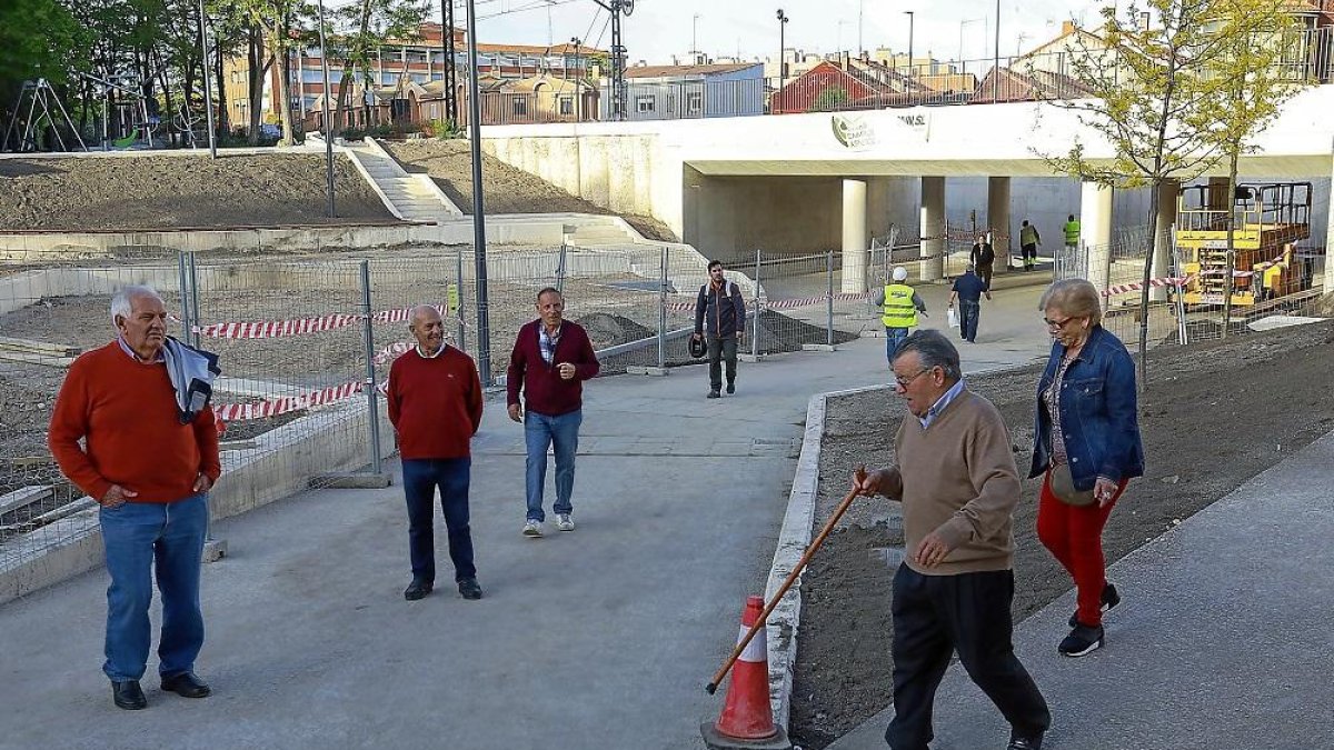 Los primeros usuarios del nuevo paso bajo las vías de La Pilarica, en la plaza de Rafael Cano.-J.M. LOSTAU