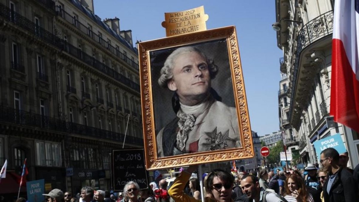 Los manifestantes contrarios a Macron muestran un retrato del rey Luis XIV con la cara del actual presidente.-/ FRANÇOIS MORI / AFP