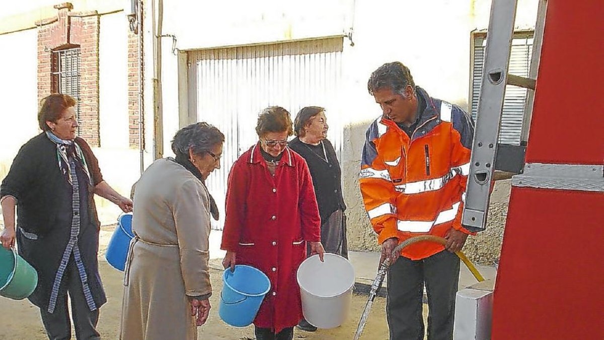Vecinas de un pueblo de la provincia acuden a un camión cisterna para proveerse de agua potable, en una imagen de archivo.-EL MUNDO