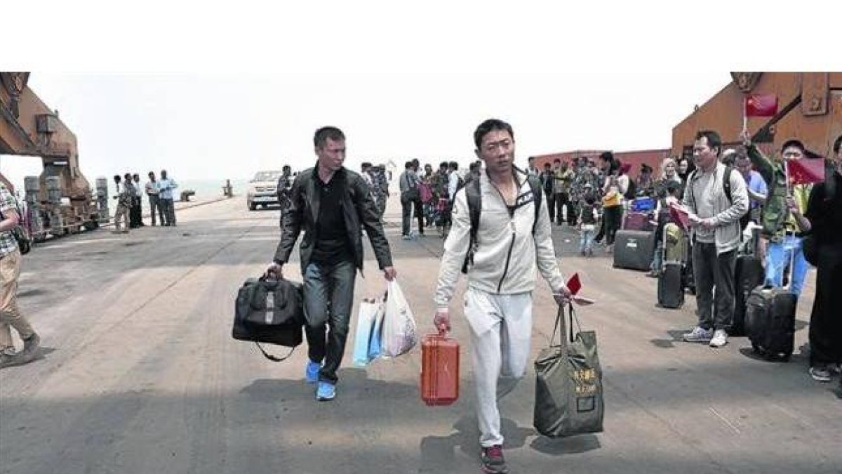 Ciudadanos chinos se preparan para embarcar en una fragata de la Armada china en Al Hudayda (Yemen).-Foto: EFE/ STR