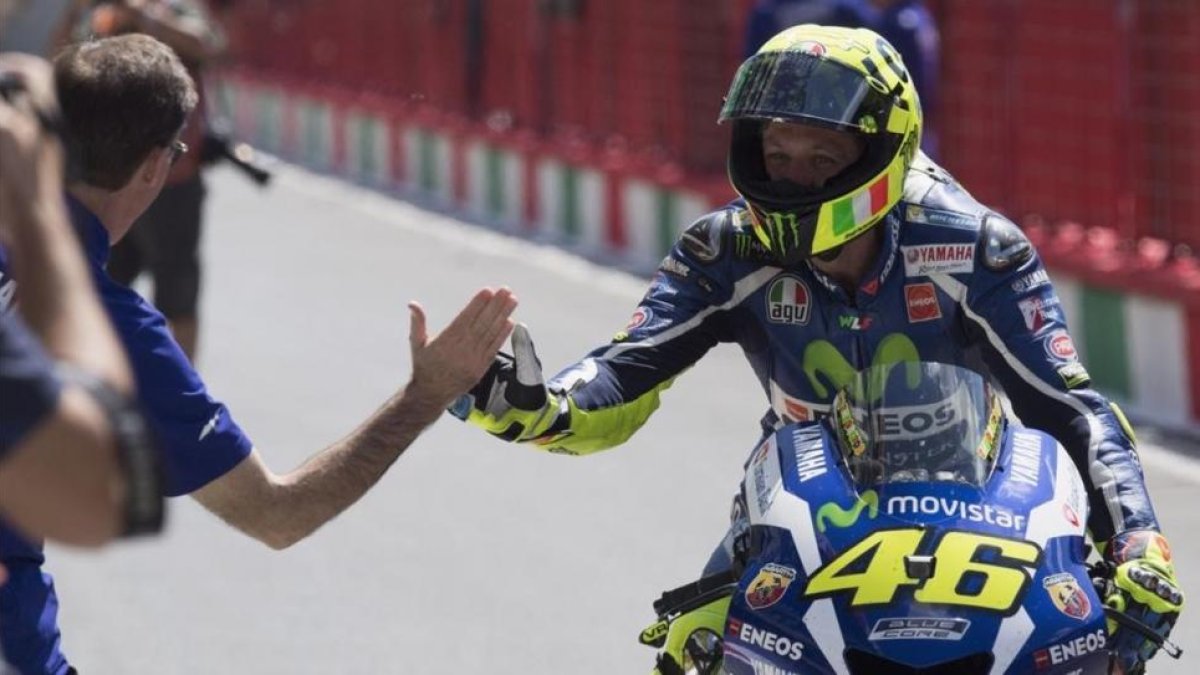 Valentino Rossi es felicitado por Lin Jarvis, jefe de Yamaha, tras conseguir la 'pole position' en Mugello con la ayuda de Maverick Viñales.-MIRCO LAZZARI