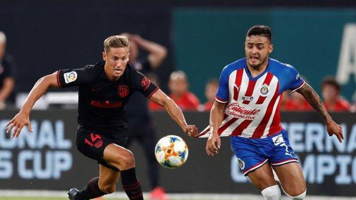 El jugador del Atlético Marcos Llorente (i) agarra al mexicano Vega en la jugada en la que fue expulsado.-EPA