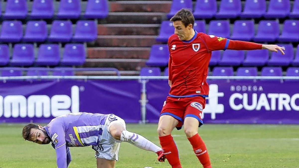 Guitián intenta disputar un balón desde el suelo.-J.M. LOSTAU