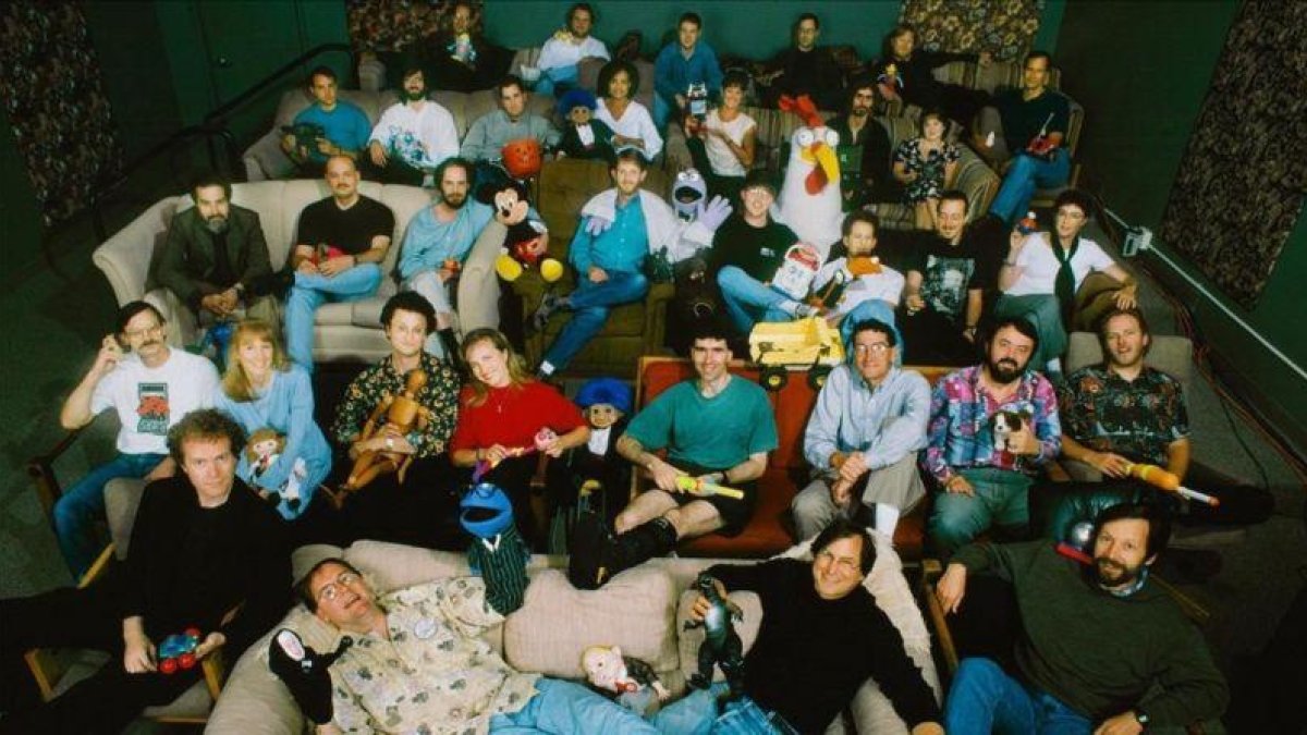 Directivos y empleados de Pixar en 1995. Abajo, John Lasseter y Steve Jobs. Sobre ellos, con la pierna entablillada, Lawrence Levy.-EL PERIÓDICO