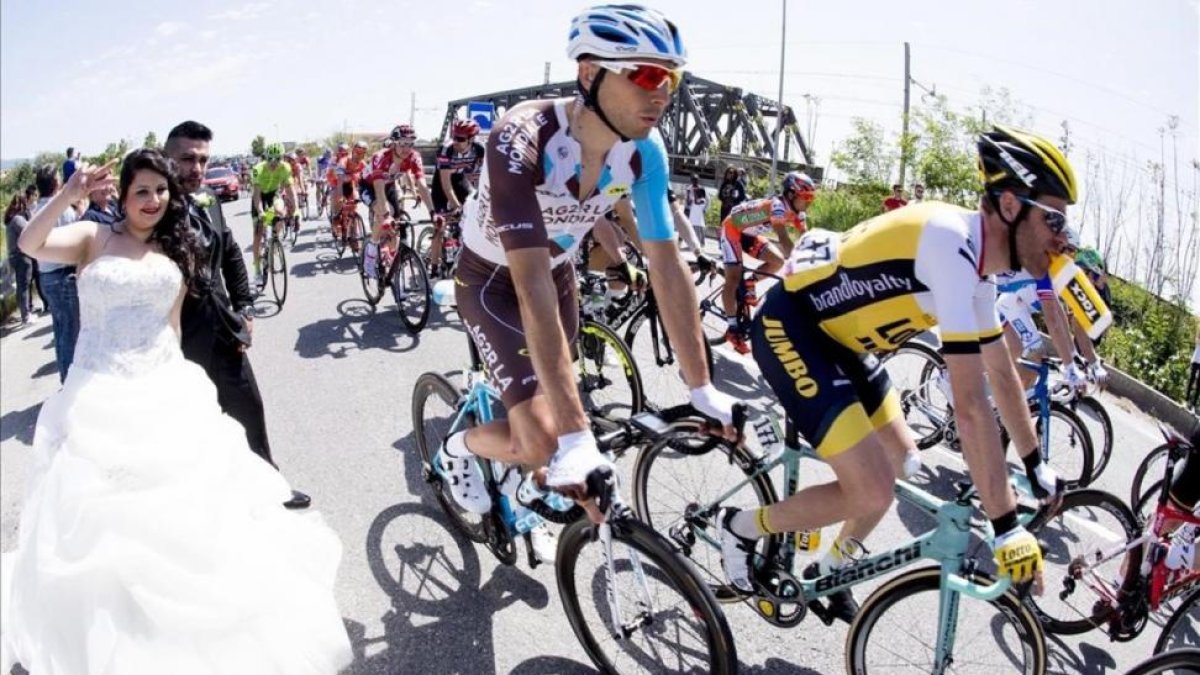 Unos recién casados, al paso de los corredores del Giro durante la cuarta etapa.-EFE / CLAUDIO PERI
