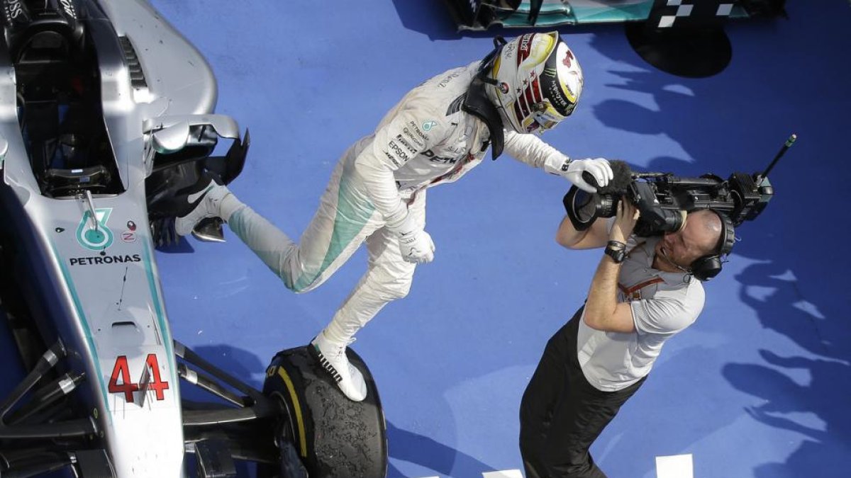 Lewis Hamilton salta de su monoplaza tras ganar el GP de Hungría.-AP / LUCA BRUNO
