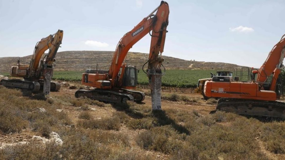 Varias máquinas esperan la orden para empezar los trabajos de construcción del asentamiento de Amijai en la Cisjordania ocupada.-AFP / MENAHEM KAHANA