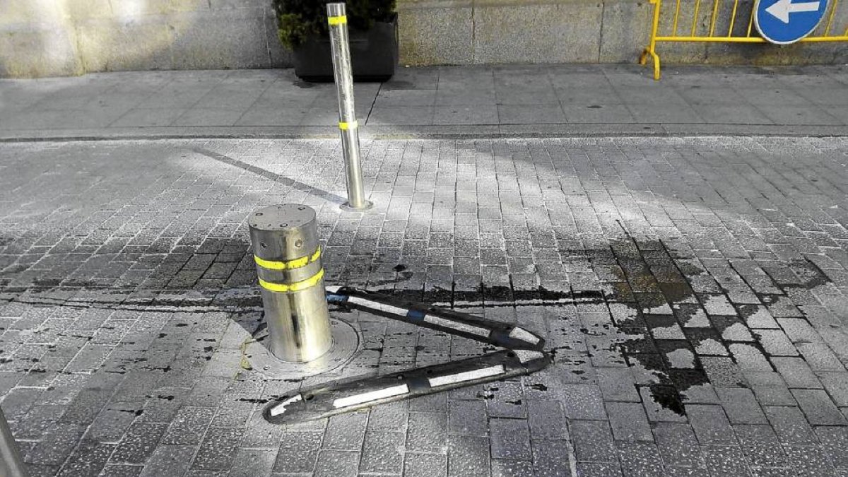El bolardo rodeado de un charco de aceite de un coche accidentado.-El Mundo