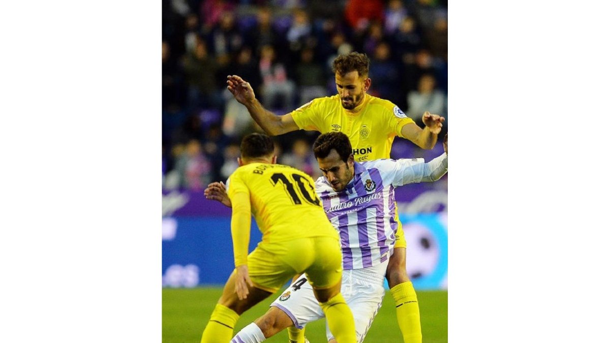 Olivas intenta cubrir el balón pero cae al suelo ante la presencia de Borja y Stuani.-LALIGA
