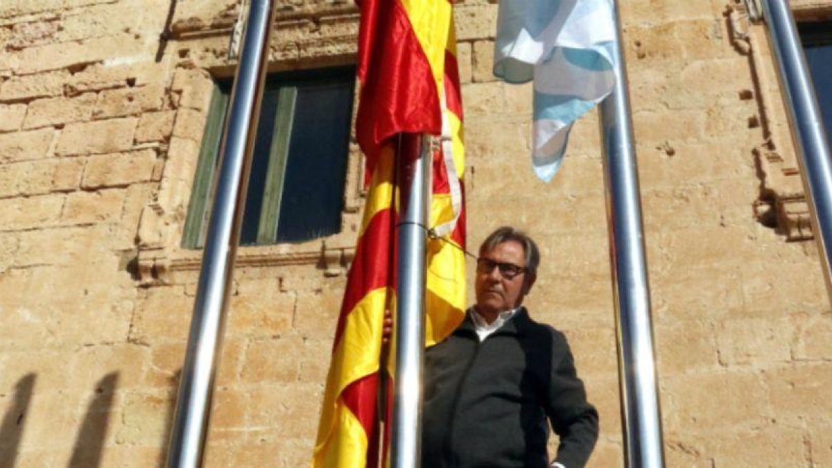 El alcalde de Torredembarra, Eduard Rovira, junto al mástil en que ha colocado la bandera española y, debajo, la 'senyera'.-ACN