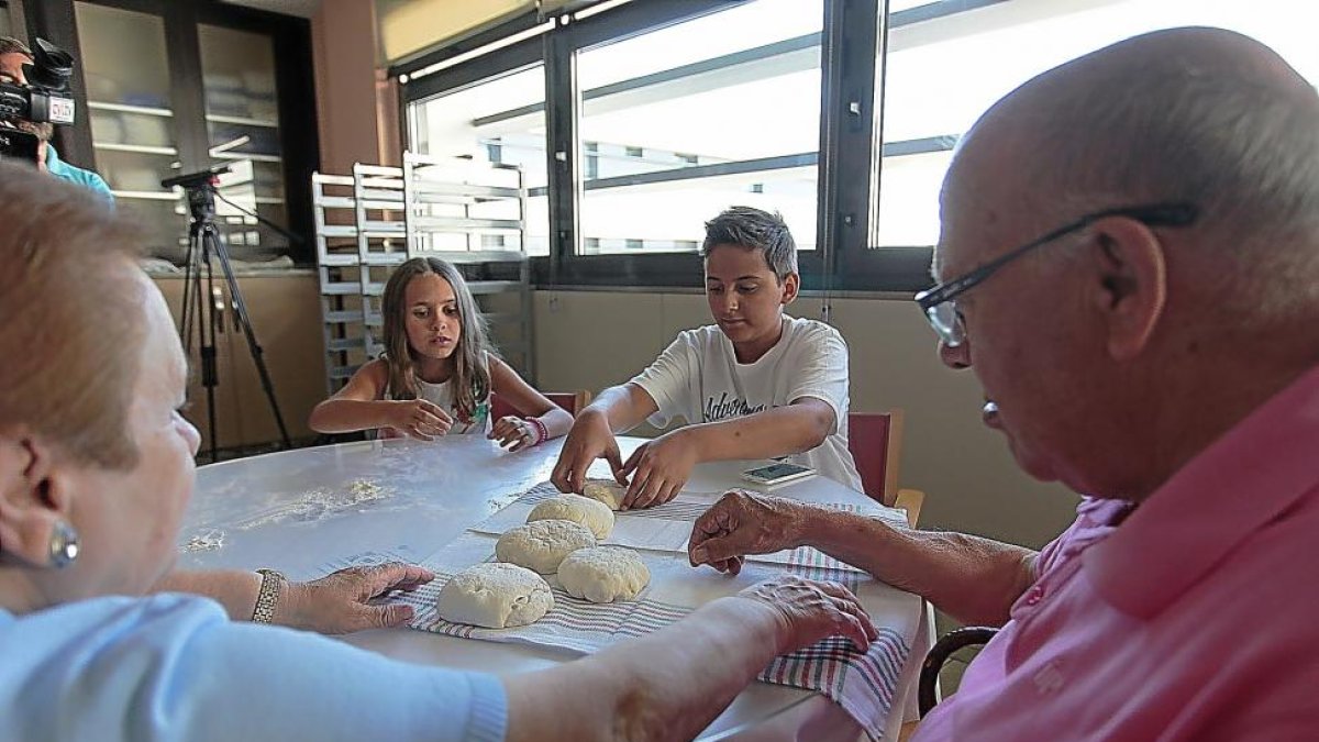 Un matrimonio disfruta del taller de pan junto a sus nietos.-JOSÉ C. CASTILLO