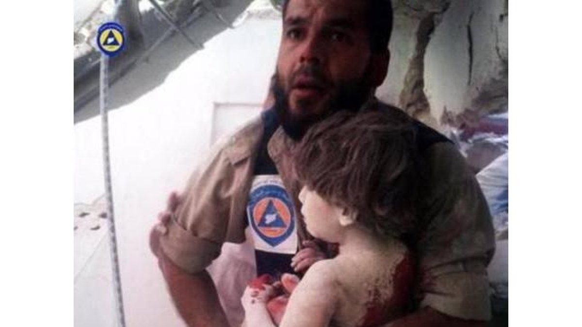 Un miembro del servicio de emergencias rescata a un niño víctima de los bombardeos rusos.-