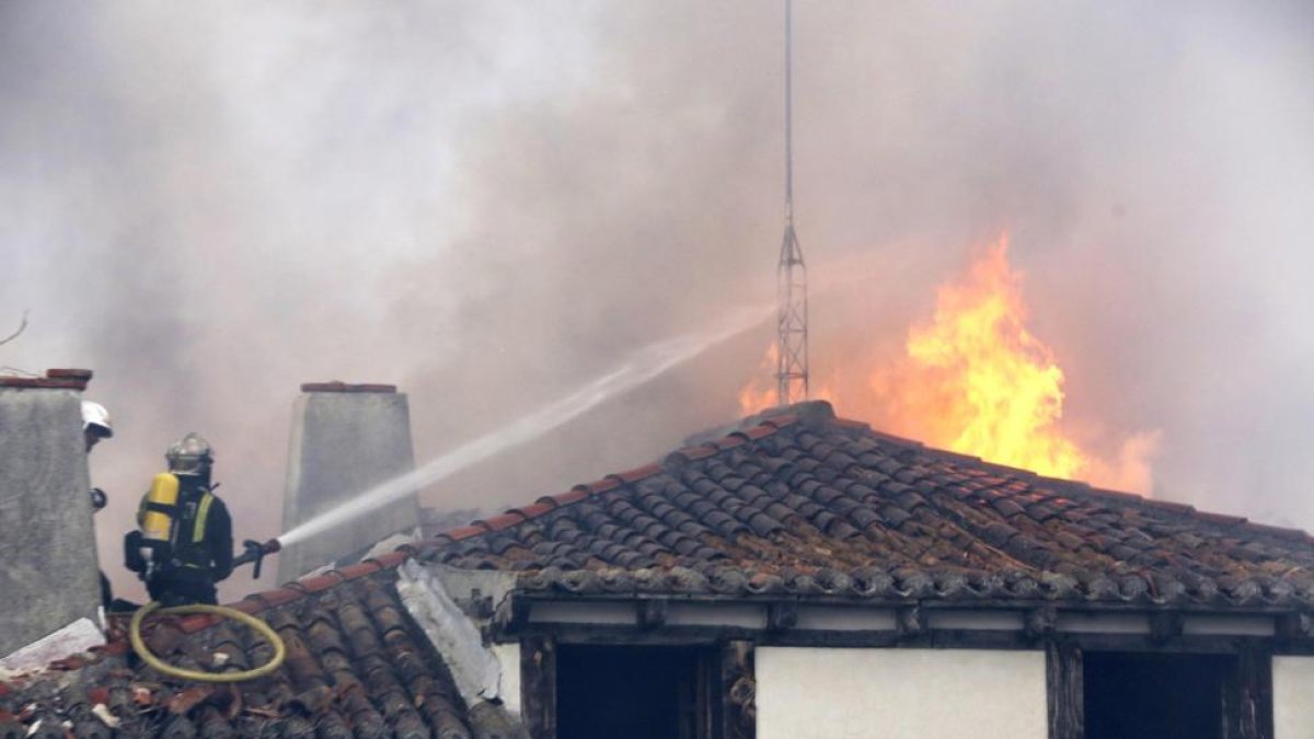 Un bombero actúa en el tejado.-ICAL