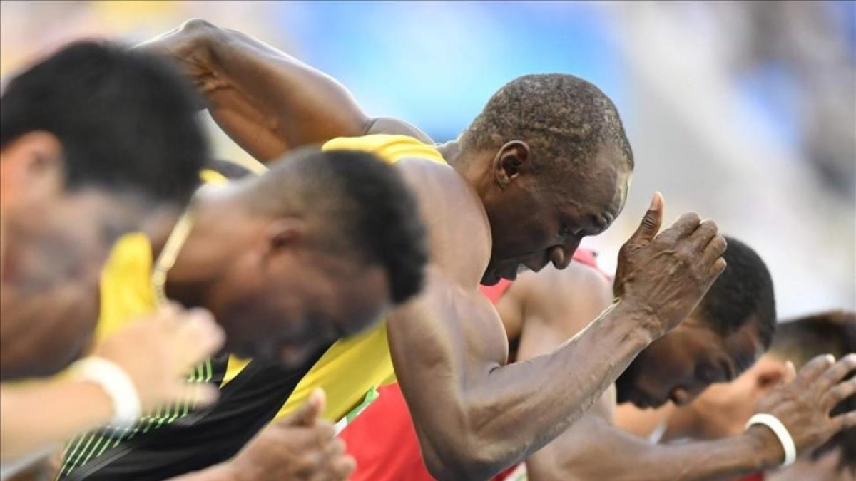 Usain Bolt toma la salida en las series de los 100 metros, su debut en los Juegos de Río.-AFP / FABRICE COFFRIN