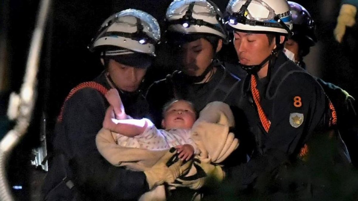Un bebé de ocho meses rescatado por los trabajadores de emergencias este viernes en Japón.-HANDOUT