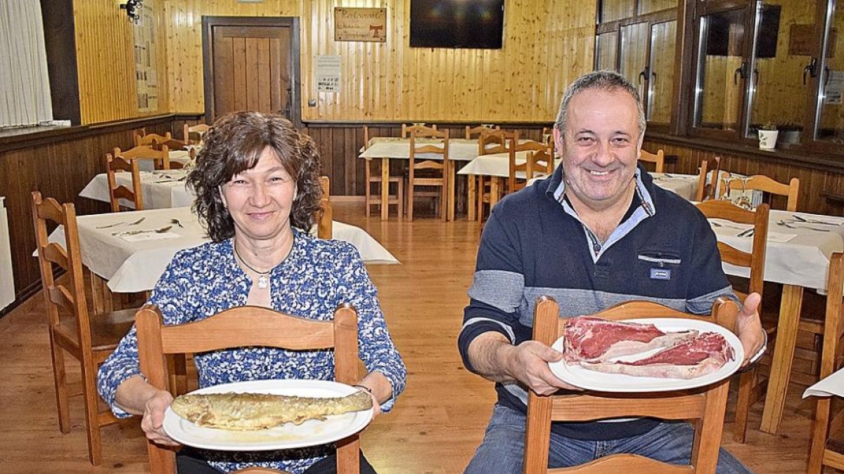 Mª Teresa y Benjamín, con truchas y carnes, dos productos obligados en su establecimiento.-ARGICOMUNICACIÓN