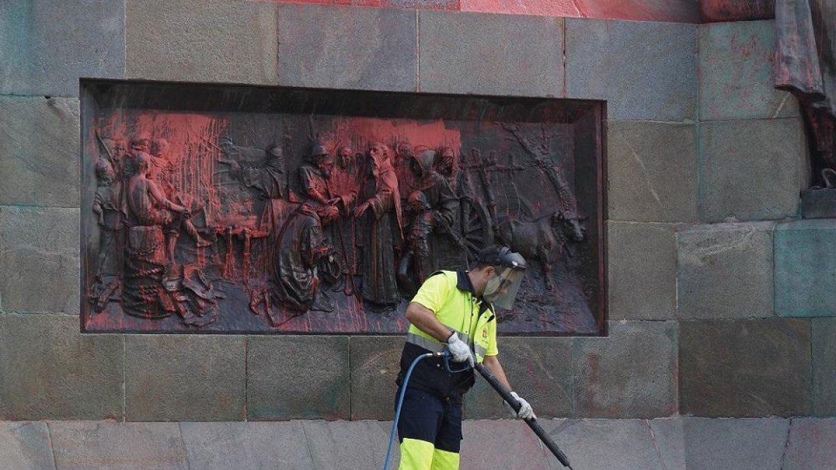 Empleado limpiando las pintadas del Monumento Colón a primera hora de la mañana el pasado 12 de octubre.- PHOTOGENIC / MIGUEL ÁNGEL SANTOS