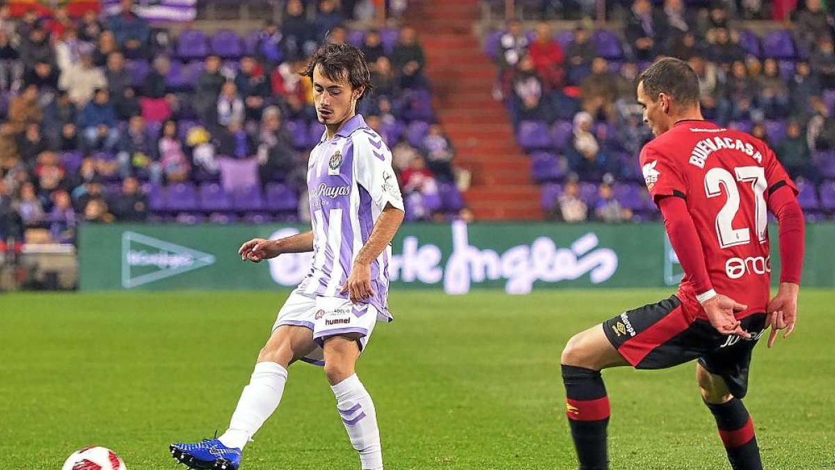 Apa da un pase con el mallorquinista Buenacasa mirando el balón.-P.R.