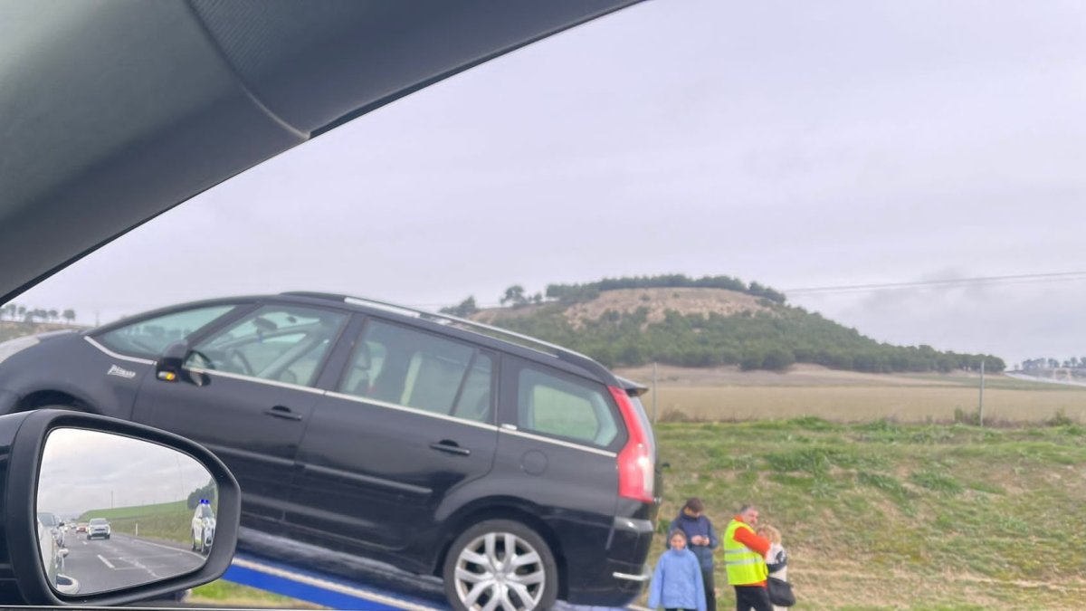 Momento en el que la grúa retira el coche averiado en la A-6.- E. M.