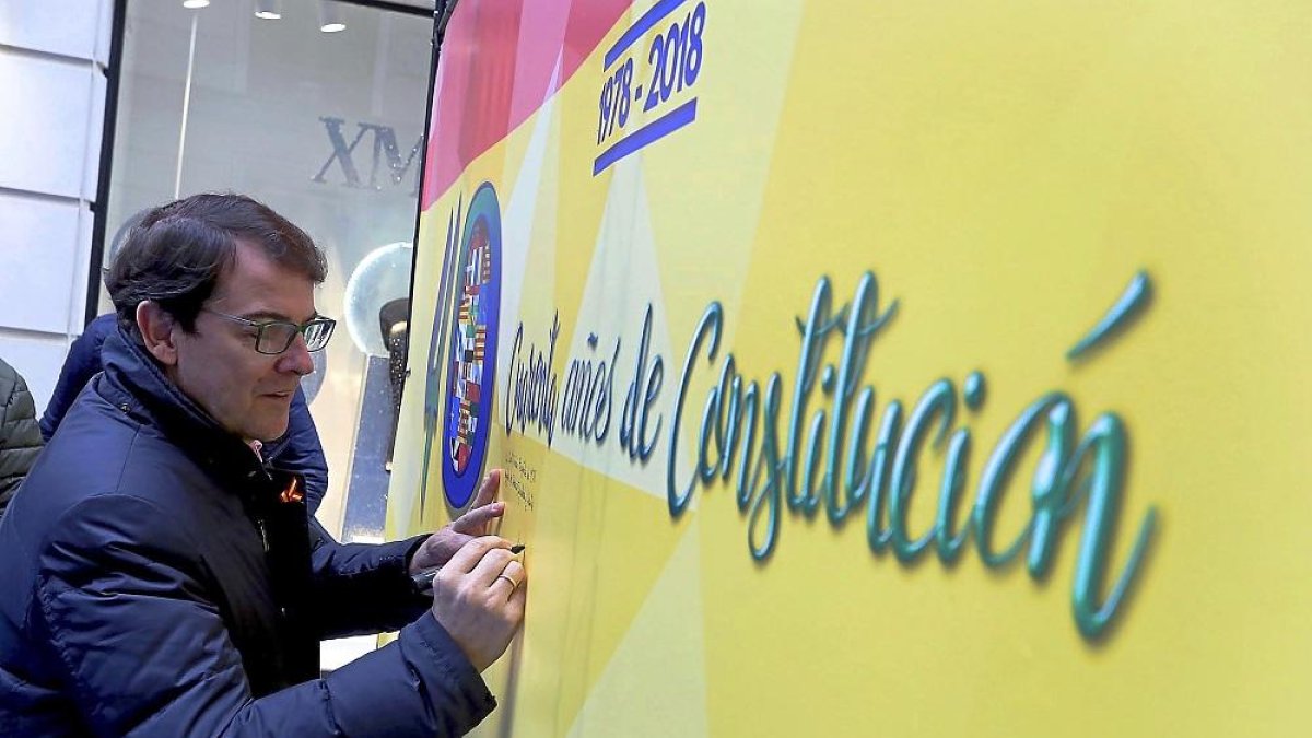 Alfonso Fernández Mañueco deja su dedicatoria en el cartel durante el acto de celebración.-ICAL