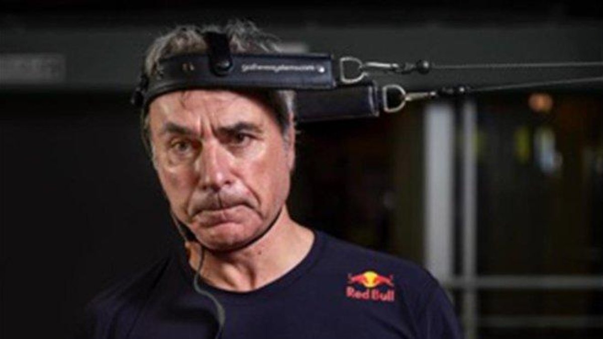 Carlos Sainz con el rostro desencajado, haciendo ejercicios para fortalecer su cuello.-RED BULLMEDIA