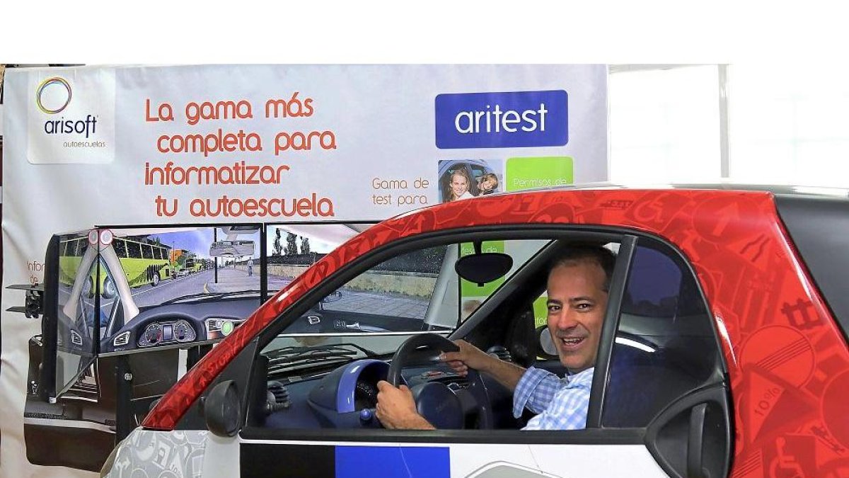 Carlos Arias posa en uno de los vehículos que sirve de simulador para sacarse el carné de conducir.-J. L. C.