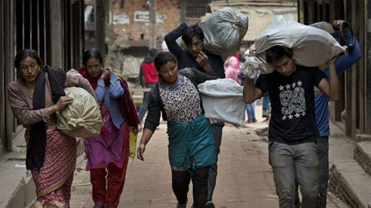 Ciudadanos de Bhaktapur, en Nepal, acarreando sus enseres.-Foto: AFP / BERNAT ARMANGUE