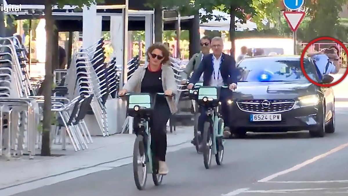 Momento de la llegada de Teresa Ribera en bici a la cumbre, mientras detrás graba con medio cuerpo fuera del coche uno de los miembros de su equipo.-E. M.