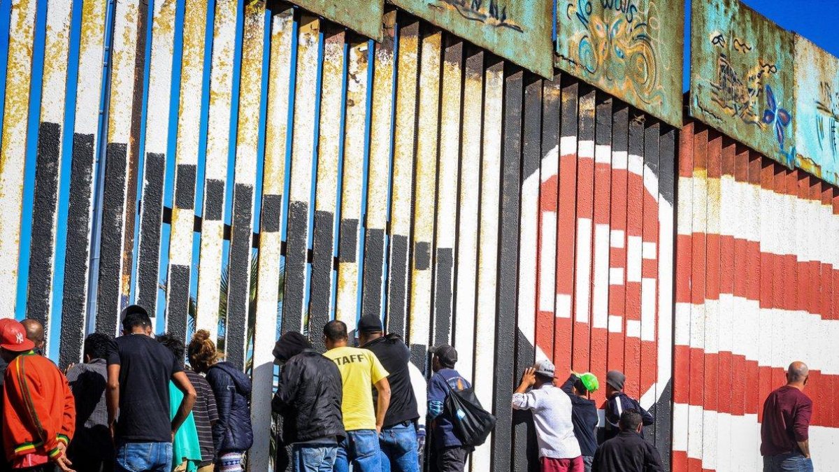 Migrantes de la primera caravana que salio desde honduras y recorrio el territorio mexicano comienzan a congregarse en la valla fronteriza de Tijuana Mexico.-EFE Joebeth Terrique