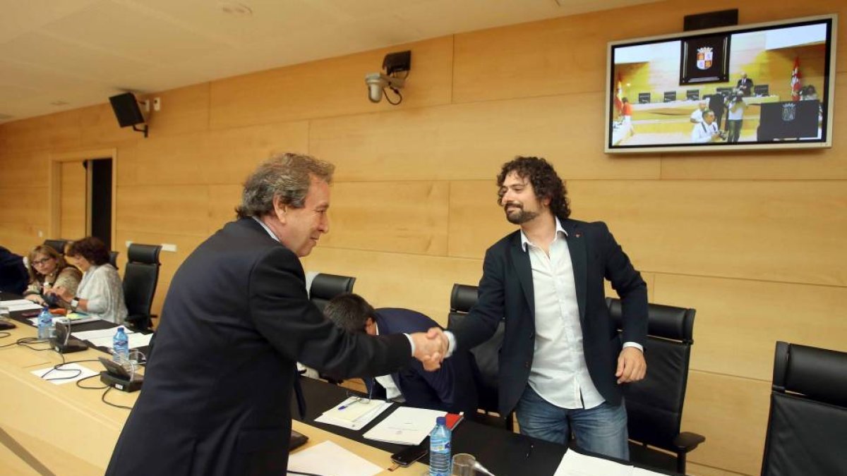 El consejero de la Presidencia, José Antonio de Santiago-Juárez, saluda al portavoz de Izquierda Unida, José Sarrión, antes de comparecer en las Cortes para exponer el programa de legislatura-Ical