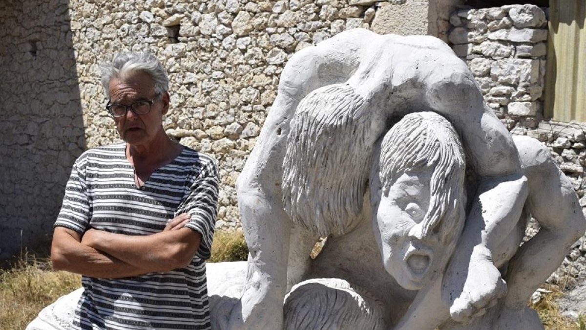Luciano Santos, junto a su escultura de piedra El Parió, en su taller de Olombrada.-ARGICOMUNICACIÓN