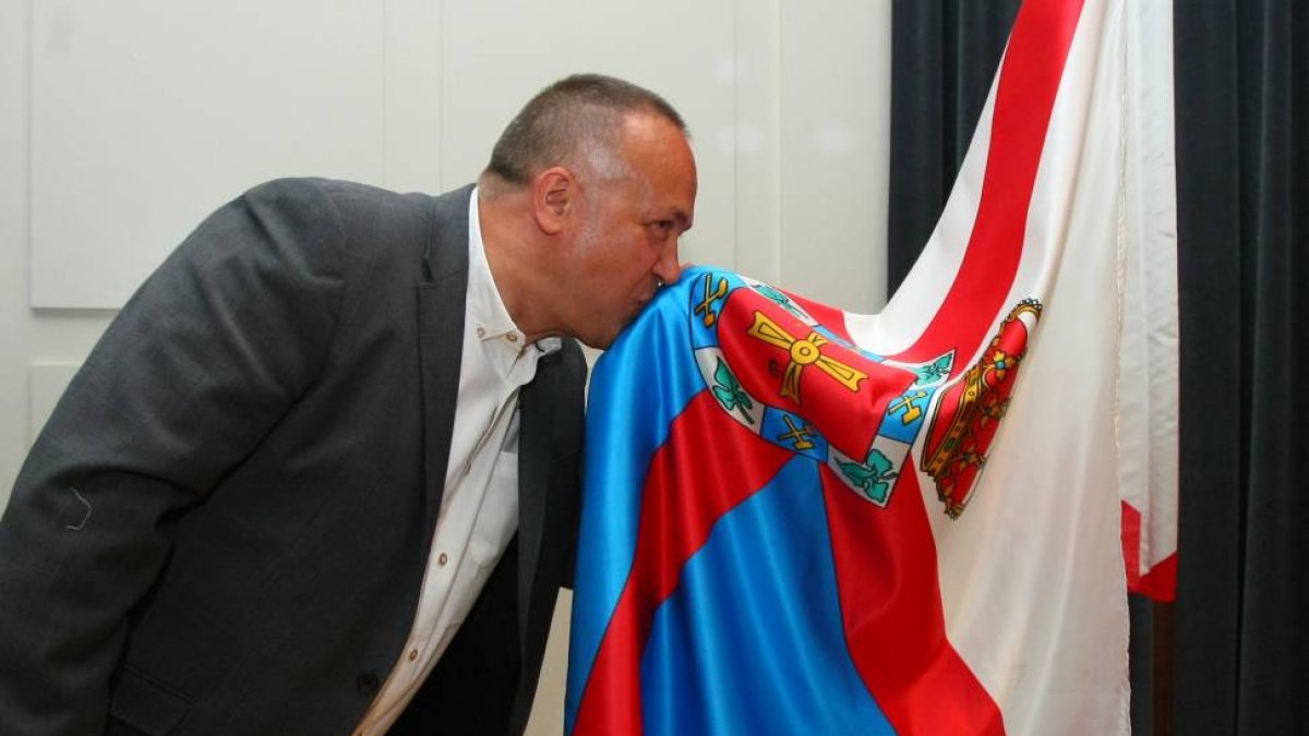 El nuevo presidente del Consejo Comarcal del Bierzo, el socialista Gerardo Álvarez Courel, besa la bandera del Bierzo al finalizar el pleno de constitución-ICAL