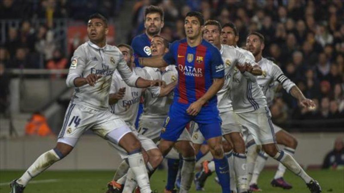 Suárez y Piqué rodeados de jugadores blancos.-FERRAN SENDRA