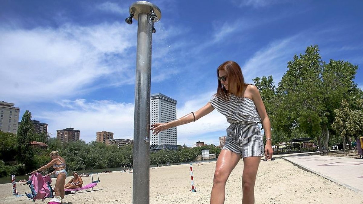 Una joven se refresca en la playa de Las Moreras de Valladolid para suavizar el calor en una imagen de archivo. E.M.