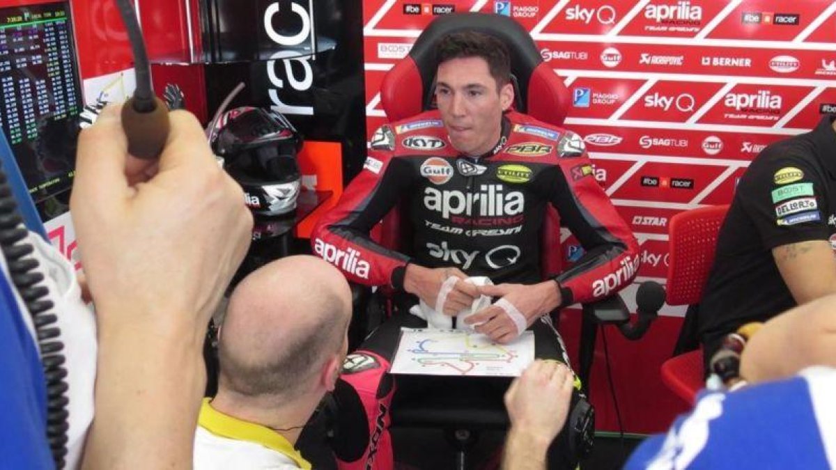 El catalán Aleix Espargaró dialoga con sus técnicos en el boxe de Aprilia en Sepang (Malasia).-EMILIO PÉREZ DE ROZAS