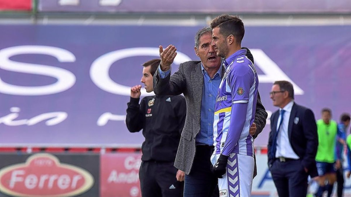 Paco Herrera da instrucciones a Juan Villar antes de salir al campo, con Anquela al fondo.-ARABA PRESS
